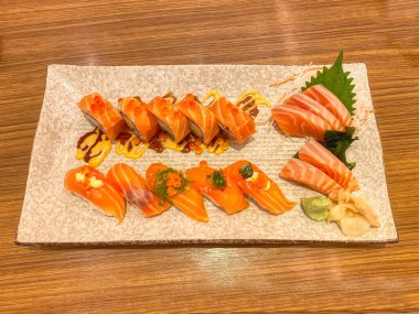 Ahşap masadaki tabakta saşimi suşisi. Suşi, Japonya kökenli bir yemek hazırlama türüdür..