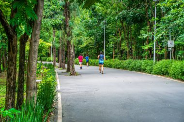 Parkta koşan insanlar. Park dinlenilecek, konuşulacak bir yerdir, herkes için..