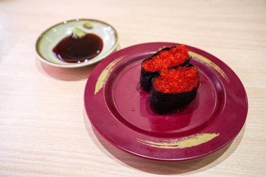 Tabakta balık yumurtası suşisi. Suşi, Japonya kökenli bir yemek hazırlama türüdür..