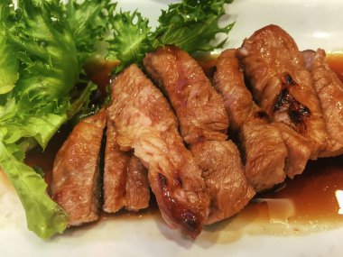 Beyaz tabakta Teriyaki soslu ızgara domuz eti..