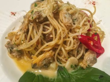 Beyaz tabakta midyeli spagetti..