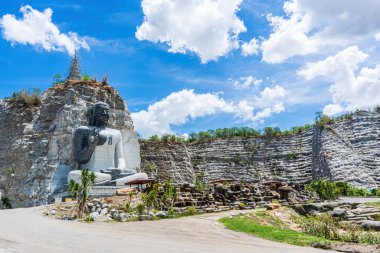 Big Lord Buddha Stone Mountain is landmark of Wat Khao Tham Thiam in province Suphanburi, Thailand. A place everyone in every religion can visit. clipart