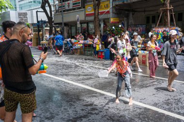 Silom, Bangkok, Tayland - APR 12, 2025 Songkran Festivali, Tayland Yeni Yılı kutlamalarına katılan insanların kısa eylemi. Sıçrama ve toz vardı. Songkran sırasında insanlar sırılsıklam oluyor..