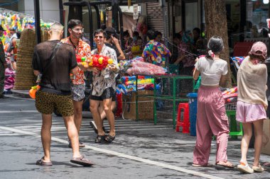 Silom, Bangkok, Tayland - APR 12, 2025 Songkran Festivali, Tayland Yeni Yılı kutlamalarına katılan insanların kısa eylemi. Sıçrama ve toz vardı. Songkran sırasında insanlar sırılsıklam oluyor..