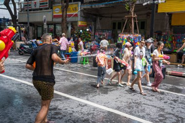 Silom, Bangkok, Tayland - APR 12, 2025 Songkran Festivali, Tayland Yeni Yılı kutlamalarına katılan insanların kısa eylemi. Sıçrama ve toz vardı. Songkran sırasında insanlar sırılsıklam oluyor..