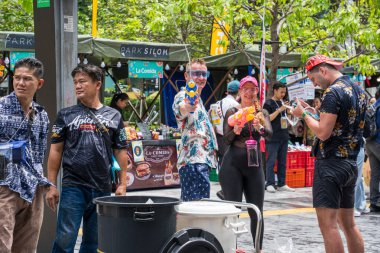 Silom, Bangkok, Tayland - APR 12, 2025 Songkran Festivali, Tayland Yeni Yılı kutlamalarına katılan insanların kısa eylemi. Sıçrama ve toz vardı. Songkran sırasında insanlar sırılsıklam oluyor..