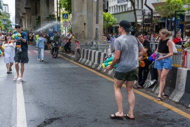 Silom, Bangkok, Tayland - APR 12, 2025 Songkran Festivali, Tayland Yeni Yılı kutlamalarına katılan insanların kısa eylemi. Sıçrama ve toz vardı. Songkran sırasında insanlar sırılsıklam oluyor..
