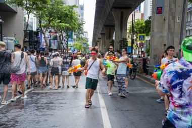 Silom, Bangkok, Tayland - APR 12, 2025 Songkran Festivali, Tayland Yeni Yılı kutlamalarına katılan insanların kısa eylemi. Sıçrama ve toz vardı. Songkran sırasında insanlar sırılsıklam oluyor..