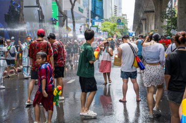 Silom, Bangkok, Tayland - APR 12, 2025 Songkran Festivali, Tayland Yeni Yılı kutlamalarına katılan insanların kısa eylemi. Sıçrama ve toz vardı. Songkran sırasında insanlar sırılsıklam oluyor..