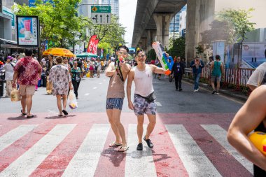 Silom, Bangkok, Tayland - APR 12, 2025 Songkran Festivali, Tayland Yeni Yılı kutlamalarına katılan insanların kısa eylemi. Sıçrama ve toz vardı. Songkran sırasında insanlar sırılsıklam oluyor..