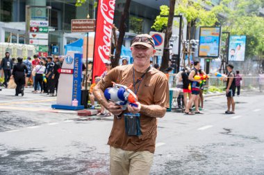 Silom, Bangkok, Tayland - APR 12, 2025 Songkran Festivali, Tayland Yeni Yılı kutlamalarına katılan insanların kısa eylemi. Sıçrama ve toz vardı. Songkran sırasında insanlar sırılsıklam oluyor..