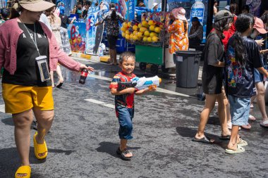 Silom, Bangkok, Tayland - APR 12, 2025 Songkran Festivali, Tayland Yeni Yılı kutlamalarına katılan insanların kısa eylemi. Sıçrama ve toz vardı. Songkran sırasında insanlar sırılsıklam oluyor..