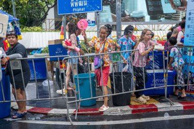 Silom, Bangkok, Tayland - APR 12, 2025 Songkran Festivali, Tayland Yeni Yılı kutlamalarına katılan insanların kısa eylemi. Sıçrama ve toz vardı. Songkran sırasında insanlar sırılsıklam oluyor..