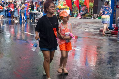 Silom, Bangkok, Tayland - APR 12, 2025 Songkran Festivali, Tayland Yeni Yılı kutlamalarına katılan insanların kısa eylemi. Sıçrama ve toz vardı. Songkran sırasında insanlar sırılsıklam oluyor..