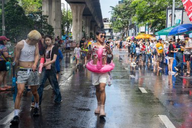 Silom, Bangkok, Tayland - APR 12, 2025 Songkran Festivali, Tayland Yeni Yılı kutlamalarına katılan insanların kısa eylemi. Sıçrama ve toz vardı. Songkran sırasında insanlar sırılsıklam oluyor..