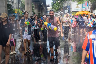 Silom, Bangkok, Tayland - APR 12, 2025 Songkran Festivali, Tayland Yeni Yılı kutlamalarına katılan insanların kısa eylemi. Sıçrama ve toz vardı. Songkran sırasında insanlar sırılsıklam oluyor..