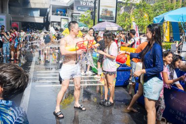 Silom, Bangkok, Tayland - APR 12, 2025 Songkran Festivali, Tayland Yeni Yılı kutlamalarına katılan insanların kısa eylemi. Sıçrama ve toz vardı. Songkran sırasında insanlar sırılsıklam oluyor..