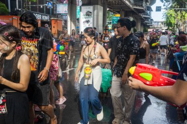 Silom, Bangkok, Tayland - APR 12, 2025 Songkran Festivali, Tayland Yeni Yılı kutlamalarına katılan insanların kısa eylemi. Sıçrama ve toz vardı. Songkran sırasında insanlar sırılsıklam oluyor..
