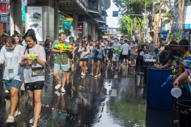Silom, Bangkok, Tayland - APR 12, 2025 Songkran Festivali, Tayland Yeni Yılı kutlamalarına katılan insanların kısa eylemi. Sıçrama ve toz vardı. Songkran sırasında insanlar sırılsıklam oluyor..