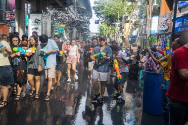 Silom, Bangkok, Tayland - APR 12, 2025 Songkran Festivali, Tayland Yeni Yılı kutlamalarına katılan insanların kısa eylemi. Sıçrama ve toz vardı. Songkran sırasında insanlar sırılsıklam oluyor..