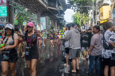 Silom, Bangkok, Tayland - APR 12, 2025 Songkran Festivali, Tayland Yeni Yılı kutlamalarına katılan insanların kısa eylemi. Sıçrama ve toz vardı. Songkran sırasında insanlar sırılsıklam oluyor..