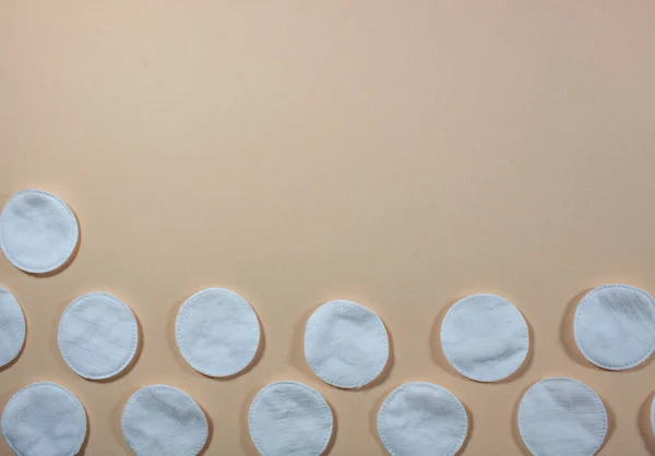 cotton pads on a light beige background top view
