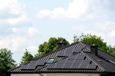 Installing a Solar Cell on a Roof. Solar panels on roof. Historic farm house with modern solar panels on roof and wall. High quality photo clipart