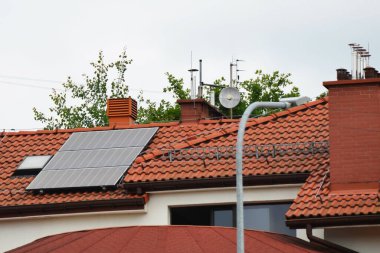 Çatıya Güneş Hücresi yerleştirmek. Çatıdaki güneş panelleri. Çatı ve duvarında modern güneş panelleri olan tarihi çiftlik evi. Yüksek kalite fotoğraf