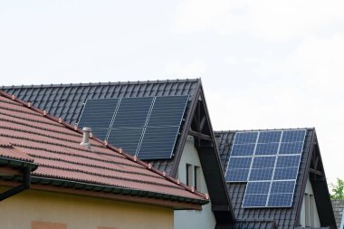 Çatıya Güneş Hücresi yerleştirmek. Çatıdaki güneş panelleri. Çatı ve duvarında modern güneş panelleri olan tarihi çiftlik evi. Yüksek kalite fotoğraf