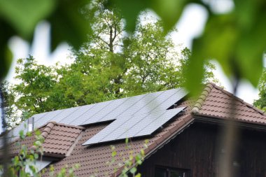 Çatıya Güneş Hücresi yerleştirmek. Çatıdaki güneş panelleri. Çatı ve duvarında modern güneş panelleri olan tarihi çiftlik evi. Yüksek kalite fotoğraf