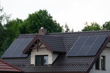 Installing a Solar Cell on a Roof. Solar panels on roof. Historic farm house with modern solar panels on roof and wall. High quality photo clipart