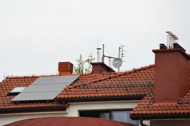 Çatıya Güneş Hücresi yerleştirmek. Çatıdaki güneş panelleri. Çatı ve duvarında modern güneş panelleri olan tarihi çiftlik evi. Yüksek kalite fotoğraf