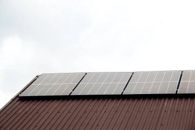 Çatıya Güneş Hücresi yerleştirmek. Çatıdaki güneş panelleri. Çatı ve duvarında modern güneş panelleri olan tarihi çiftlik evi. Yüksek kalite fotoğraf