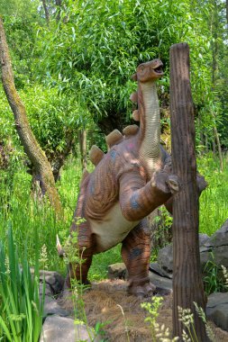 Jurasik dünyadan bir sahnede bir dinazor gösteriliyor. Parktaki dinozor modeli. Dev Tyrannosaurus parktaki bir sergide.