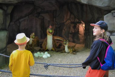 Bir çocuk için iyi bir eğlence. Bir çocuğa oyun oynayarak öğretmek. Sarı ceketli 3 yaşında yakışıklı bir çocuk dinozorların kalıntılarını kazıyor. Yüksek kalite fotoğraf.