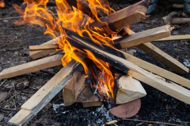 Kamp ateşinde yanan bir ateş ve arka planda kırmızı bir ateş. Yüksek kalite fotoğraf