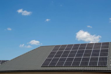 Çatıda fotovoltaik modüller var. Çatı ve duvar üzerinde modern güneş panelleri olan tarihi çiftlik evi.