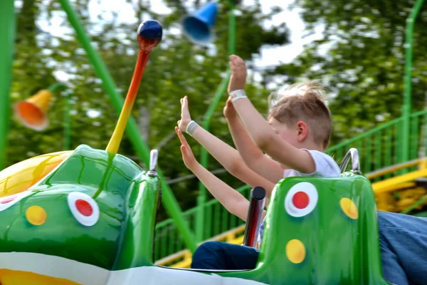 stock image Kids having fun in ferris wheel with chains, carousel ski flyer in amusement park. Happy children, twins having fun outdoors on sunny day. High quality photo