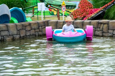2020 'de Romanya' nın Targoviste kentindeki lunaparkta çocuklar dönme dolapta zincirlerle, atlıkarınca kayak broşürleriyle eğleniyorlardı. Yüksek kalite fotoğraf