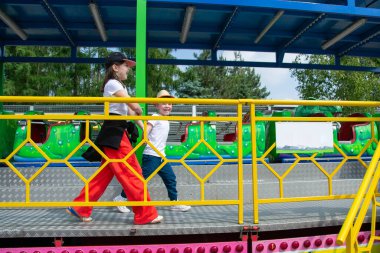 Çocuklar dönme dolapta zincirlerle, lunaparkta kayak broşürleriyle eğleniyorlar. Mutlu çocuklar, güneşli bir günde ikizler dışarıda eğleniyor. Yüksek kalite fotoğraf