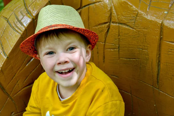 Ein Junge Mit Gelbem Hemd Und Hut Kniet Auf Einer — Stockfoto