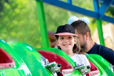 2020 'de Romanya' nın Targoviste kentindeki lunaparkta çocuklar dönme dolapta zincirlerle, atlıkarınca kayak broşürleriyle eğleniyorlardı. Yüksek kalite fotoğraf