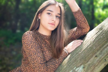 Uzun saç stili örgülü, yeşil gömlekli duygusal kız parkta bir bankta oturuyor. Yüksek kalite fotoğraf. Yüksek kalite fotoğraf