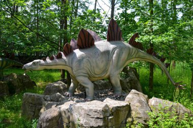 Jurasik dünyadan bir sahnede bir dinazor gösteriliyor. Parktaki dinozor modeli. Dev Tyrannosaurus parktaki bir sergide.