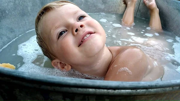 在浴缸里用泡沫微笑的男孩 高质量的照片 — 图库照片