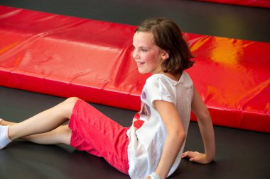 Mutlu kız trambolinde zıplarken eğleniyor. Sporcu kız trambolinde zıplıyor. Trambolinde zıplayan bir kızın açık hava çekimi, evde zıplamaktan hoşlanıyor. Mutlu yaz tatilleri.. 