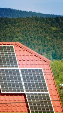 Çatıdaki güneş enerjisi standart bir eve gidiyor. Güneş enerjisi panelleri, yenilikler için fotovoltaik modüller mavi gökyüzü arka planına sahip yaşam için yeşil enerji. Yüksek kalite fotoğraf