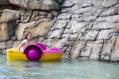 Küçük yakışıklı kıvırcık çocuk sporla meşgul, çocuk rafting ile meşgul, salda kürek çeken çocuk ya da katamaran. Yüksek kalite fotoğraf