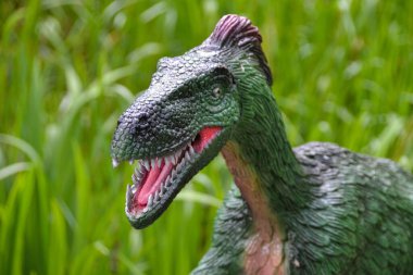Jurasik dünyadan bir sahnede bir dinazor gösteriliyor. Parktaki dinozor modeli. Dev Tyrannosaurus parktaki bir sergide.