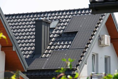 Çatıya Güneş Hücresi yerleştirmek. Çatıdaki güneş panelleri. Çatı ve duvarında modern güneş panelleri olan tarihi çiftlik evi. Yüksek kalite fotoğraf